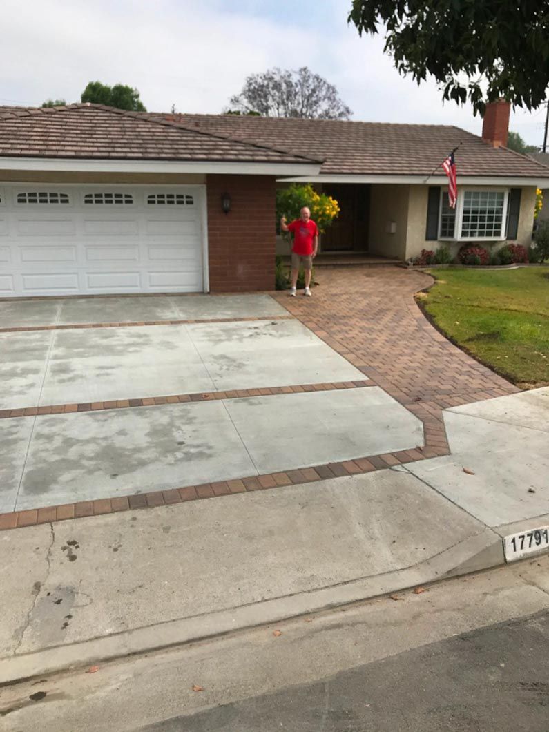 A man in a red shirt is standing in front of a house
