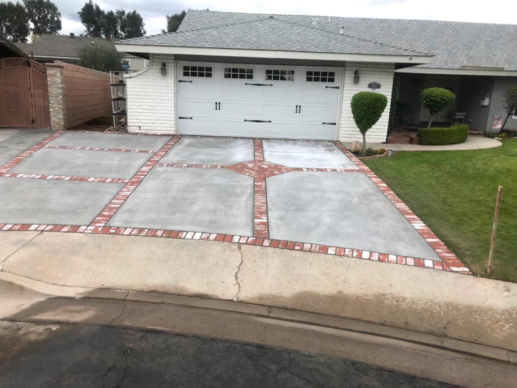A white house with a brick driveway in front of it