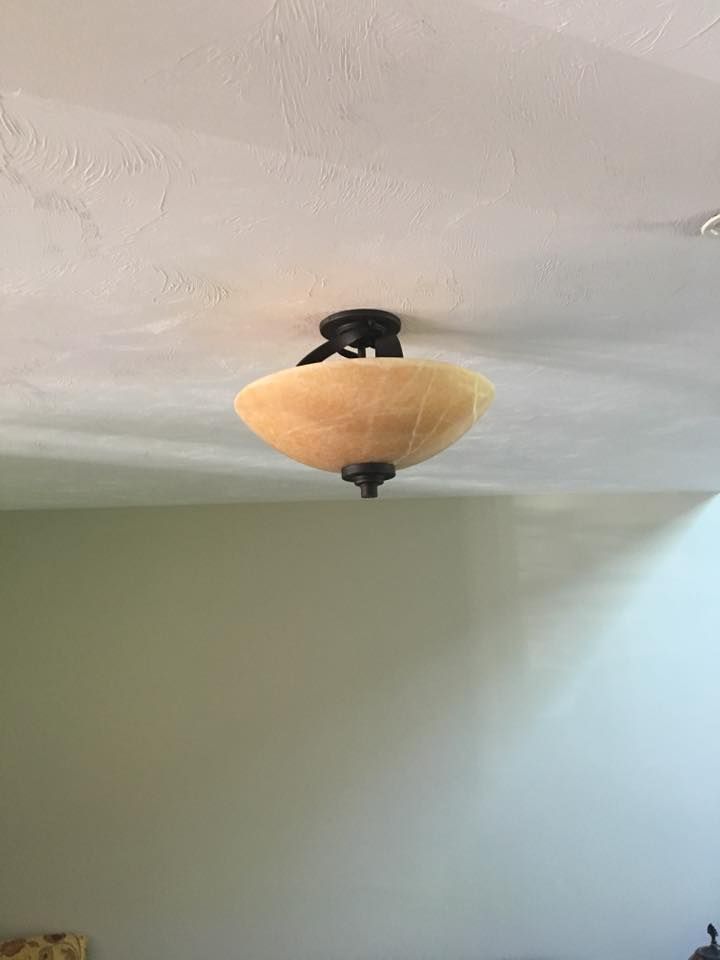 Ceiling light fixture with an amber-colored bowl-shaped shade, mounted on a white ceiling.