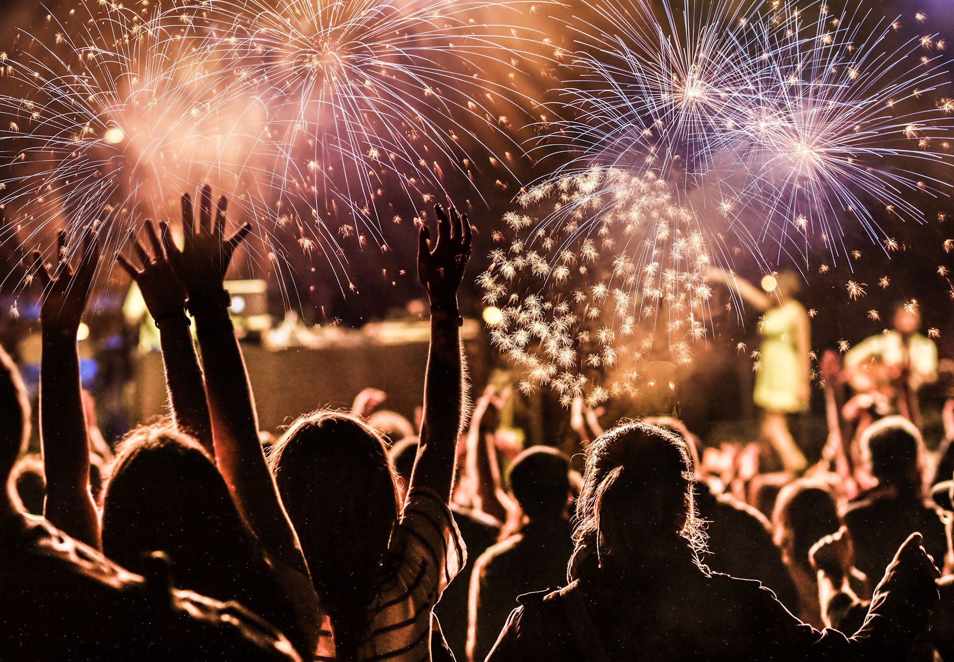 A crowd of people are watching fireworks in the sky.