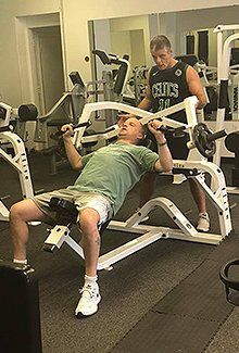 man in a green shirt working with a personal trainer
