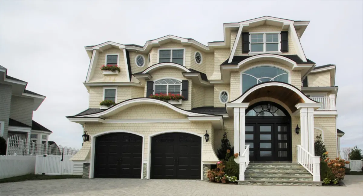 A large house with a lot of windows and black garage doors