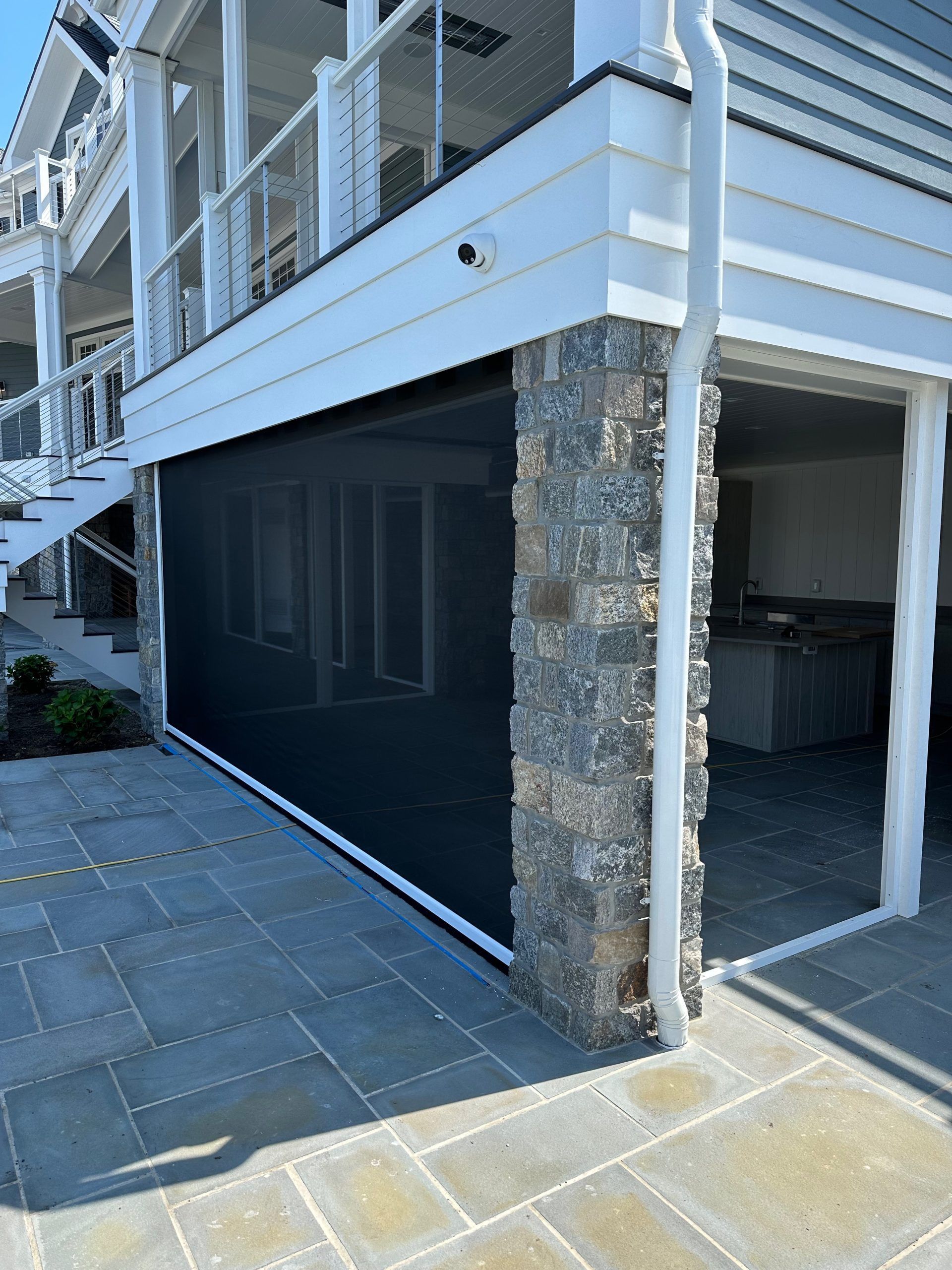 A large white house with a sliding glass door and stairs.