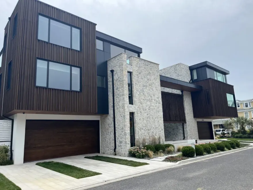 A large modern house with a lot of windows and a garage.