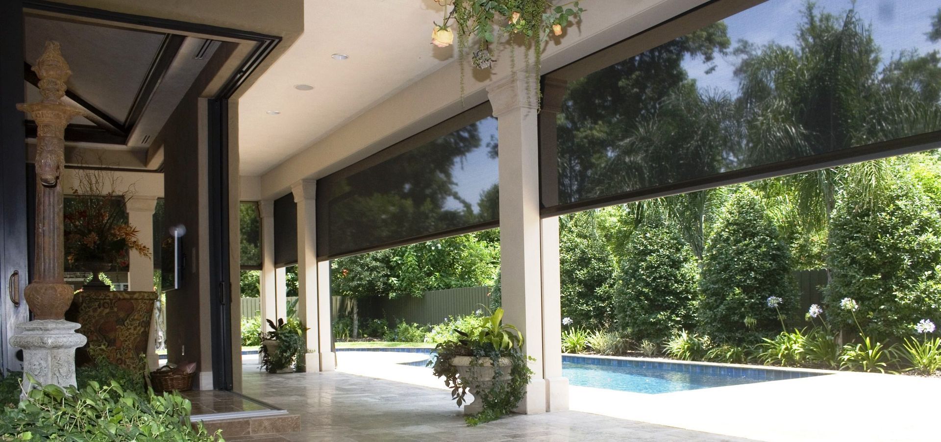 A patio with a swimming pool and trees in the background