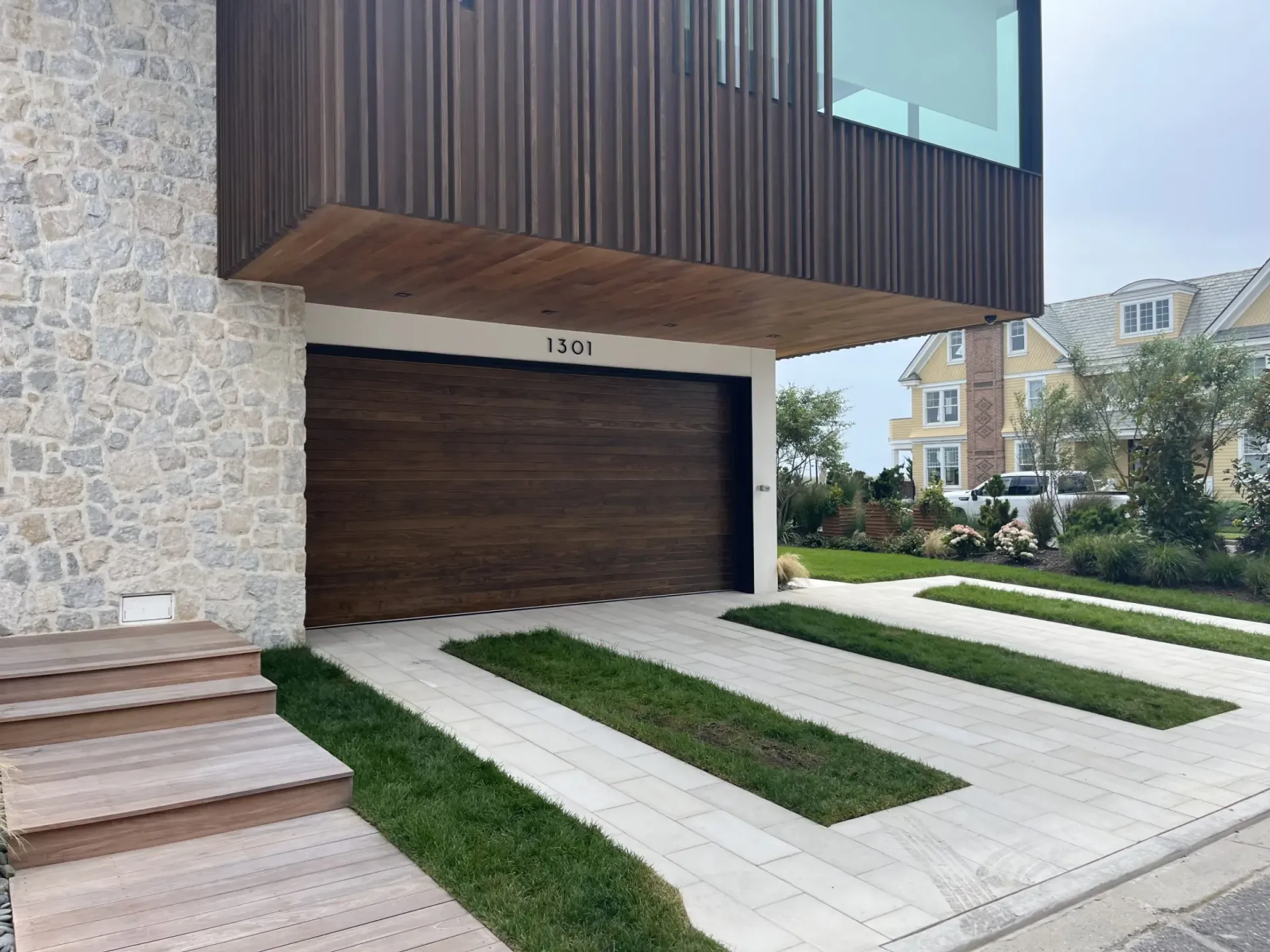 A house with a wooden garage door and a stone wall