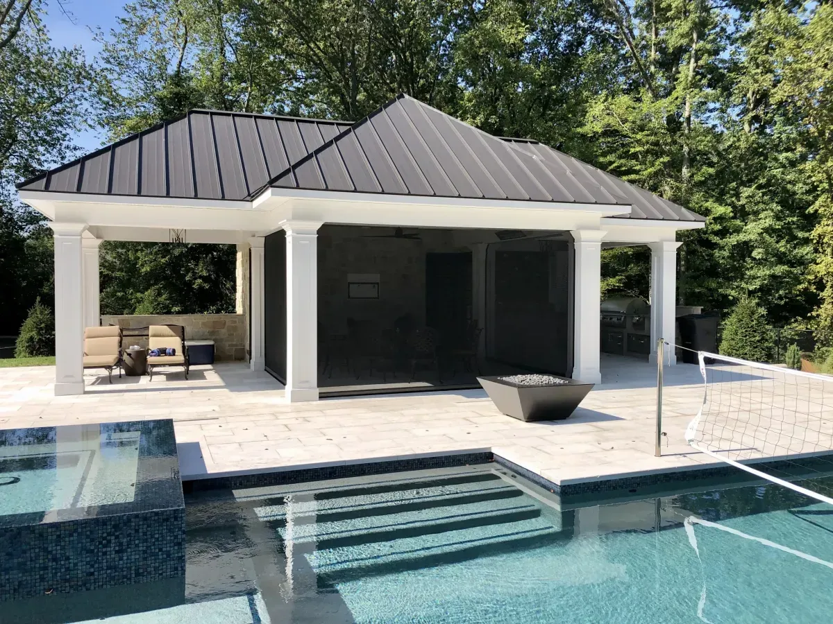 A large house with a screened in porch next to a swimming pool.