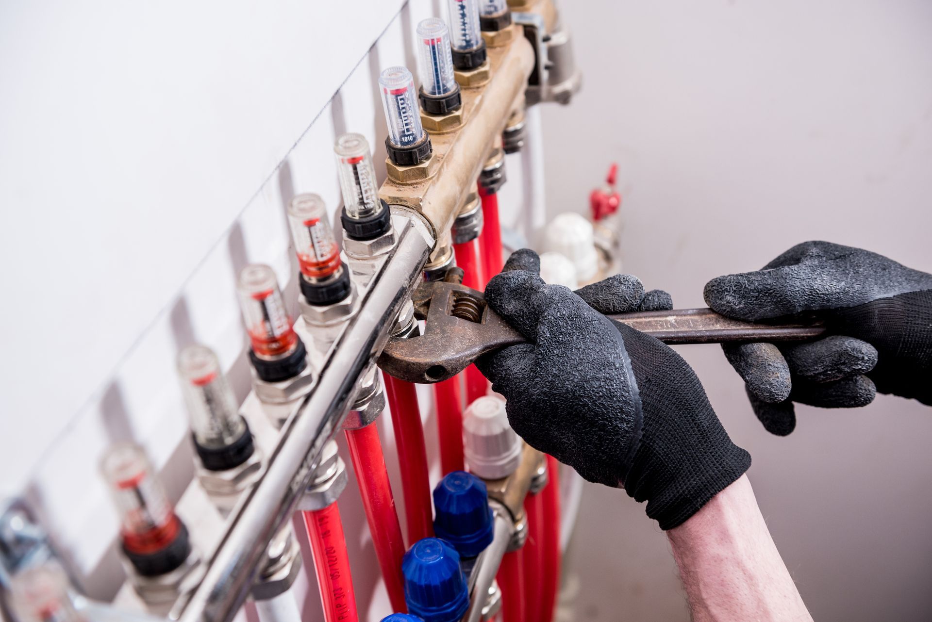 A person is working on a pipe with a wrench.