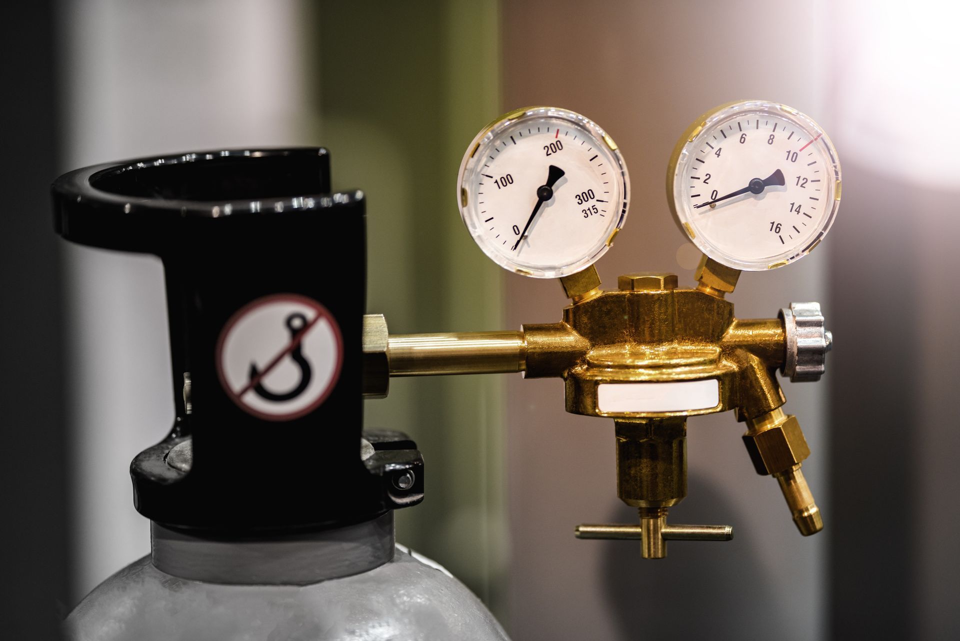 A close up of a gas cylinder with two gauges attached to it.