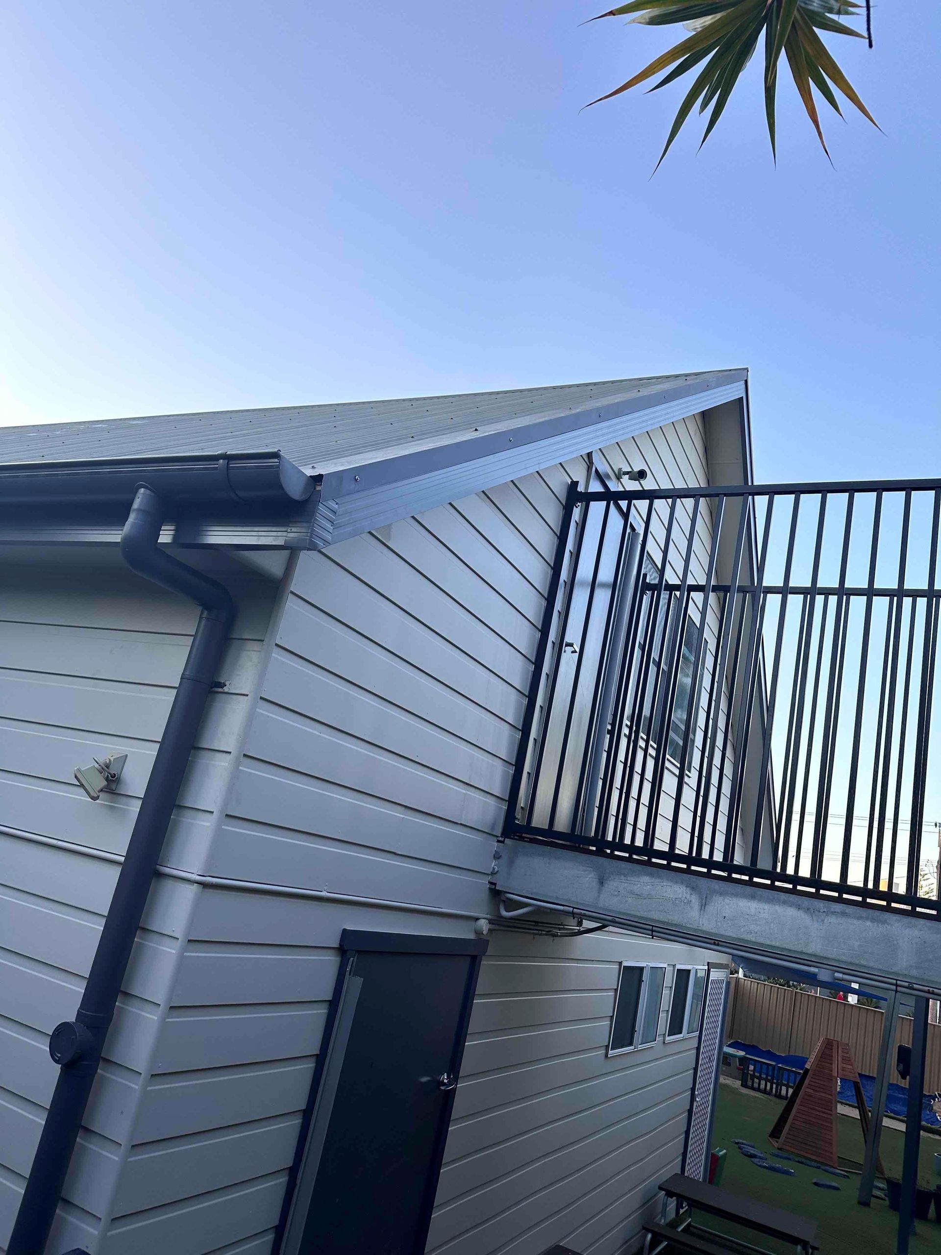 A white house with a balcony on the side of it.