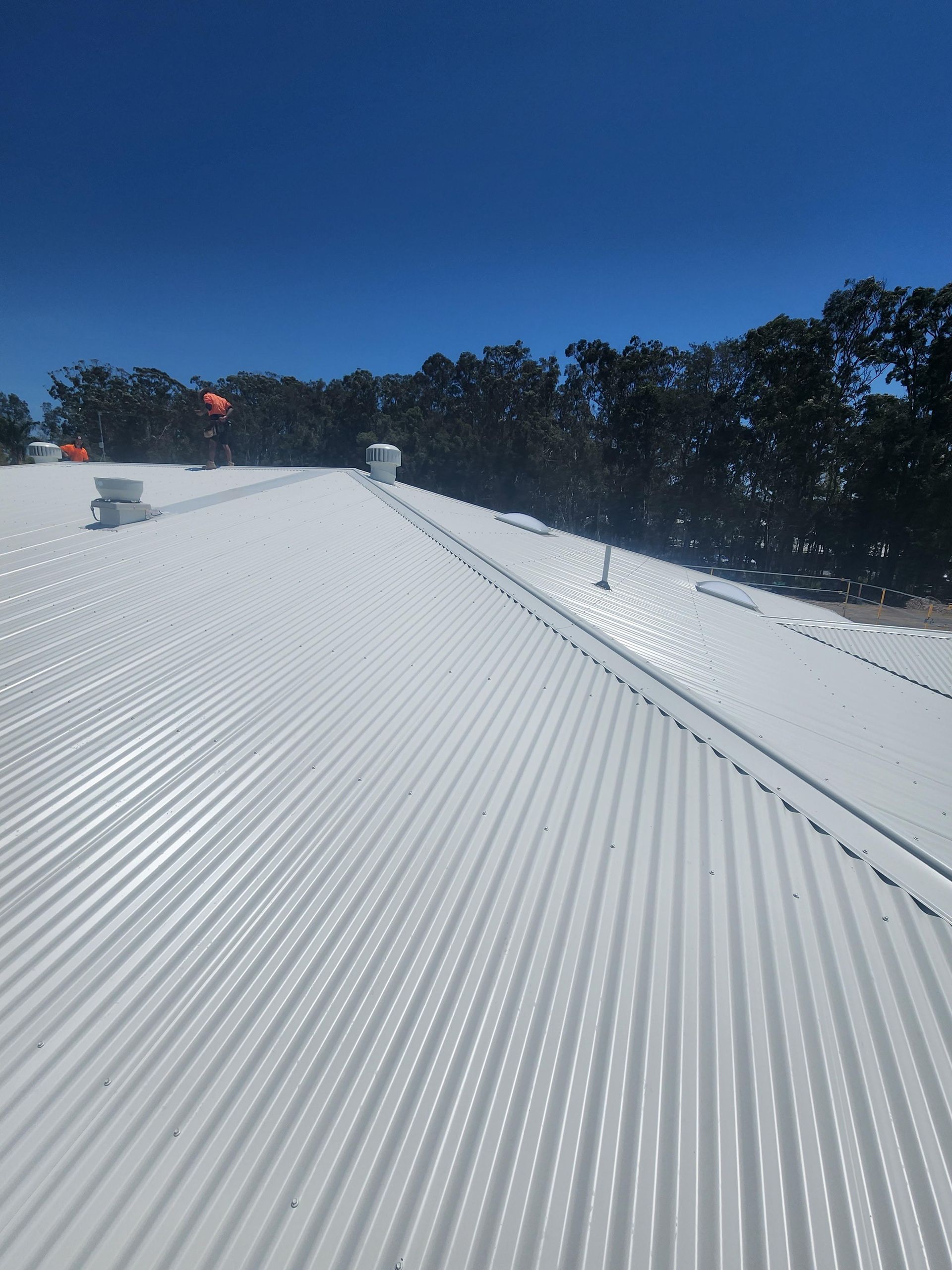 A white pipe is hanging from the ceiling of a building.