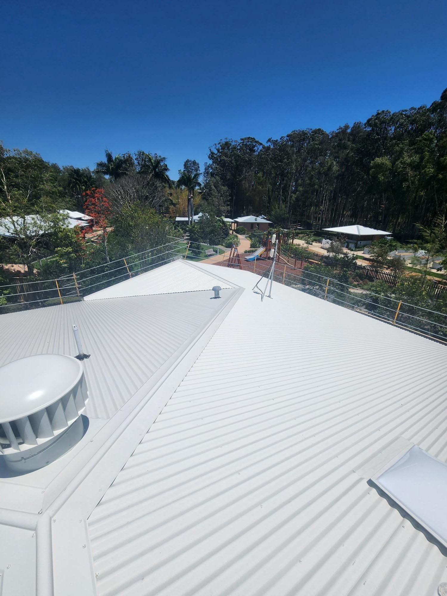 A white roof with trees in the background on a sunny day