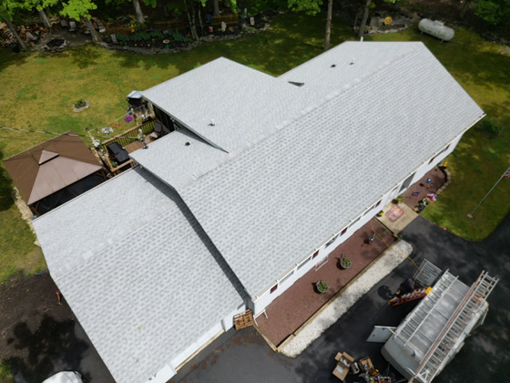 a large white house with a gray roof and a garage .