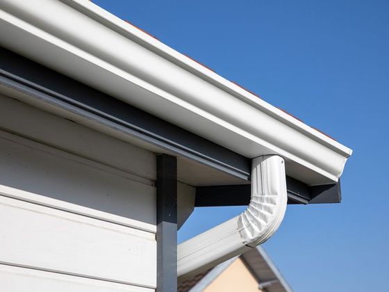 a close up of a white gutter on the side of a house .