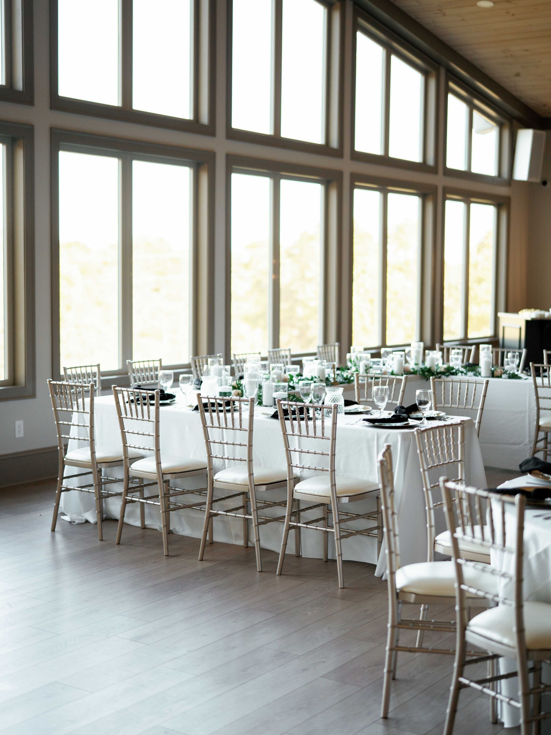 A large room with tables and chairs and lots of windows