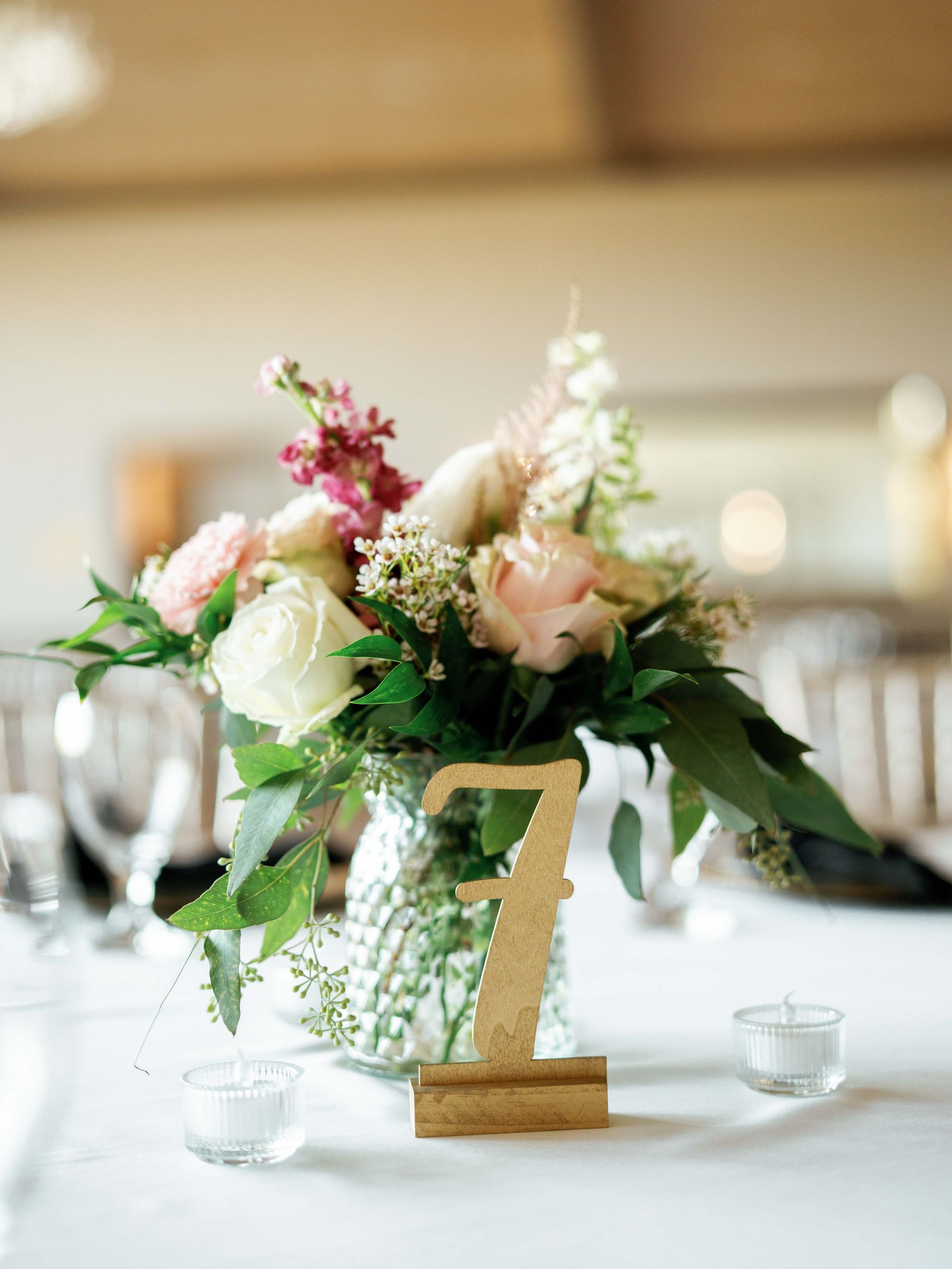 A table with a vase of flowers and a table number 7