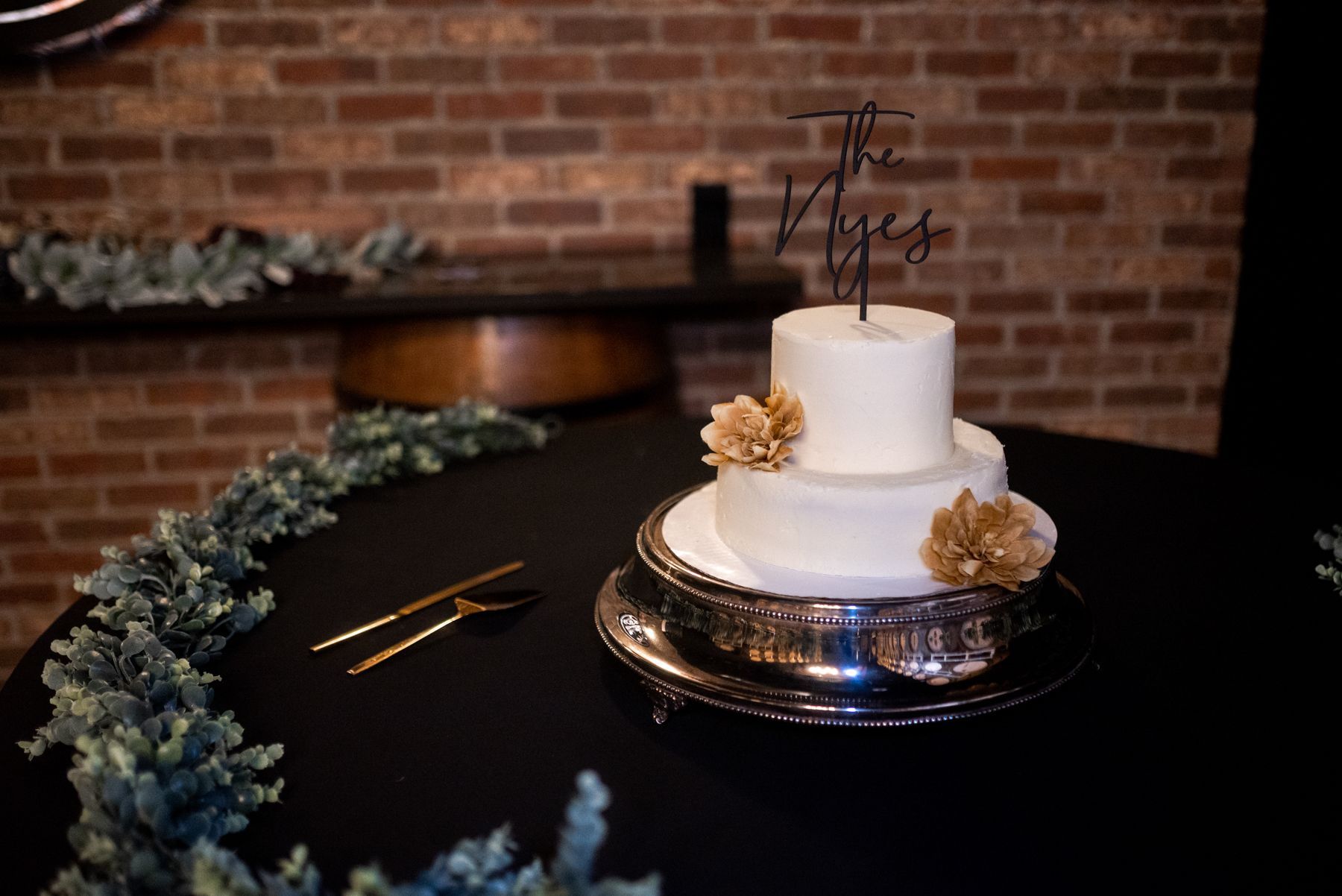 A wedding cake with a topper that says the yes