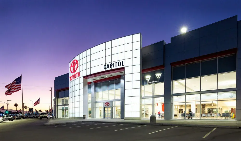 Capitol Toyota dealership exterior at dusk with American flag.
