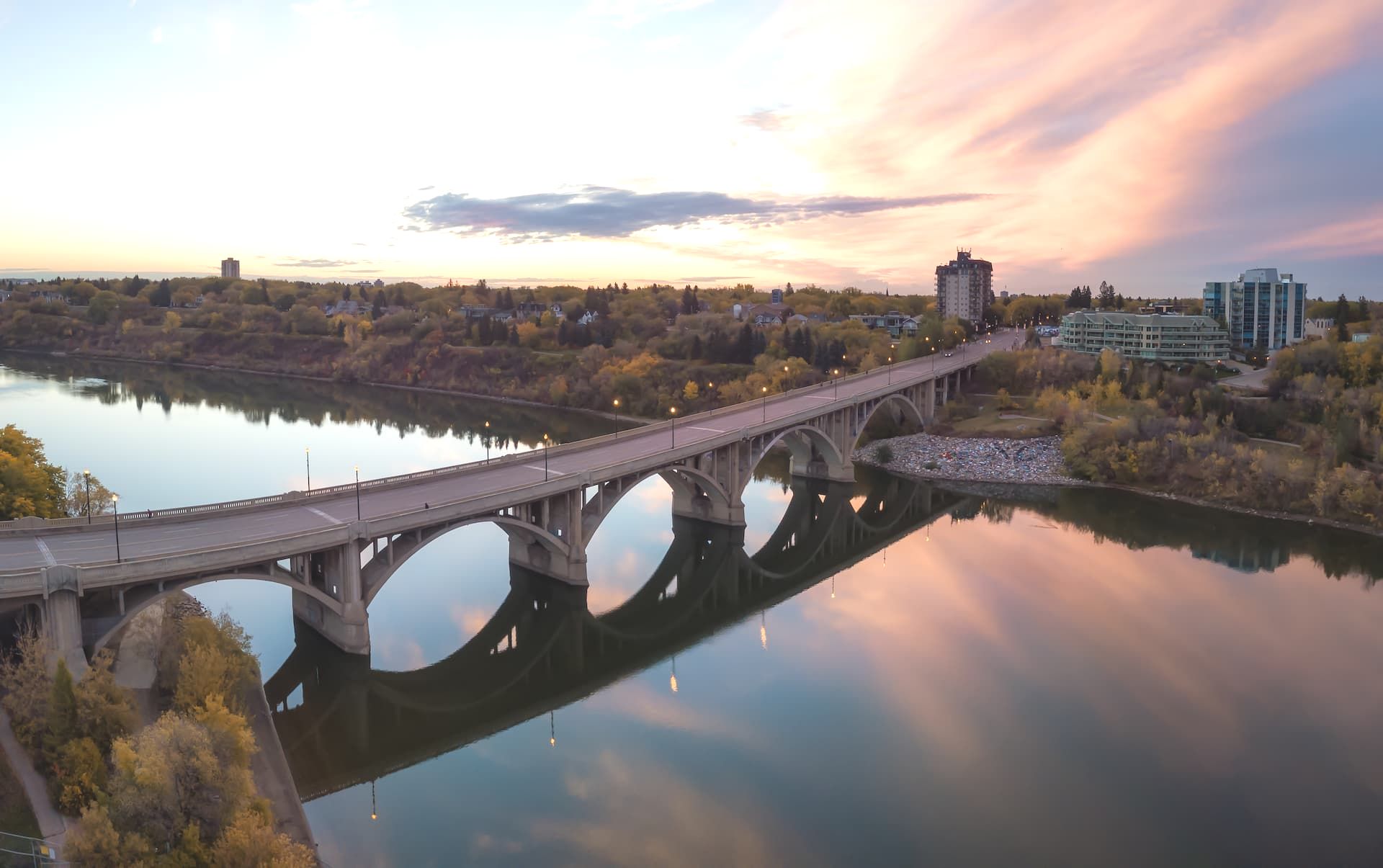 An aerial view of a bridge over a river at sunset.
