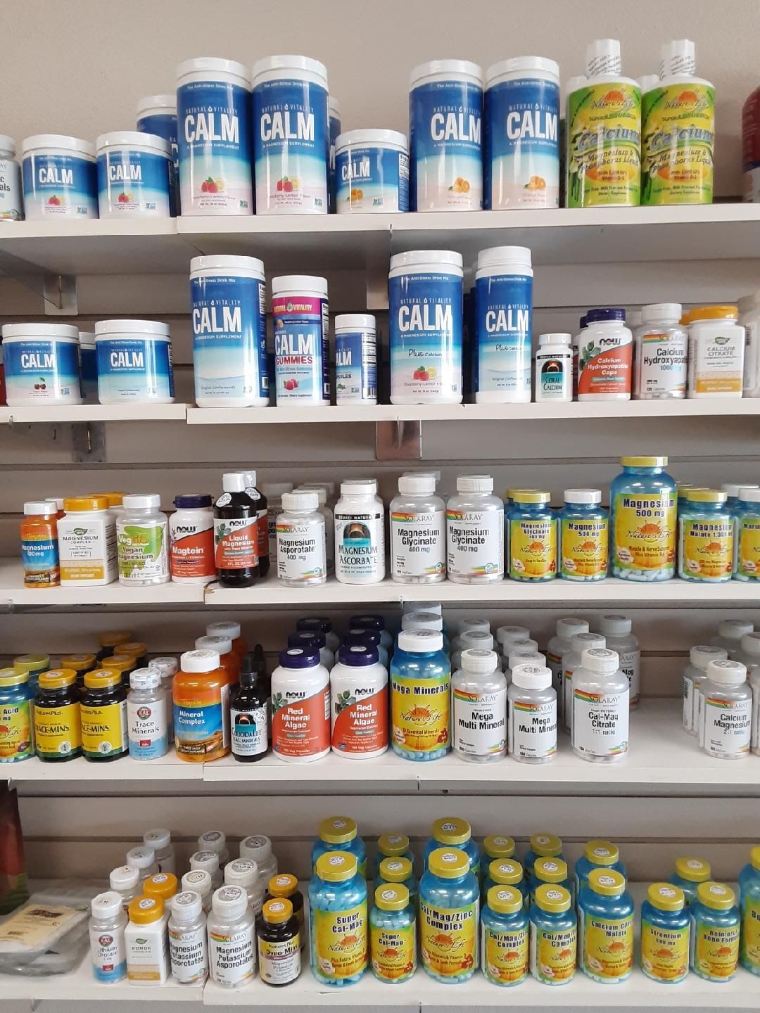 A shelf filled with lots of different types of pills and bottles.