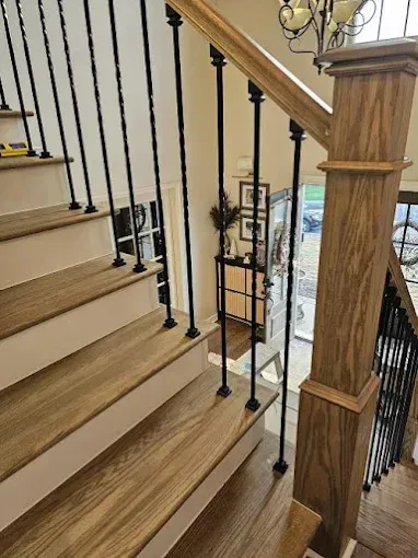 Wooden staircase with black metal spindles.