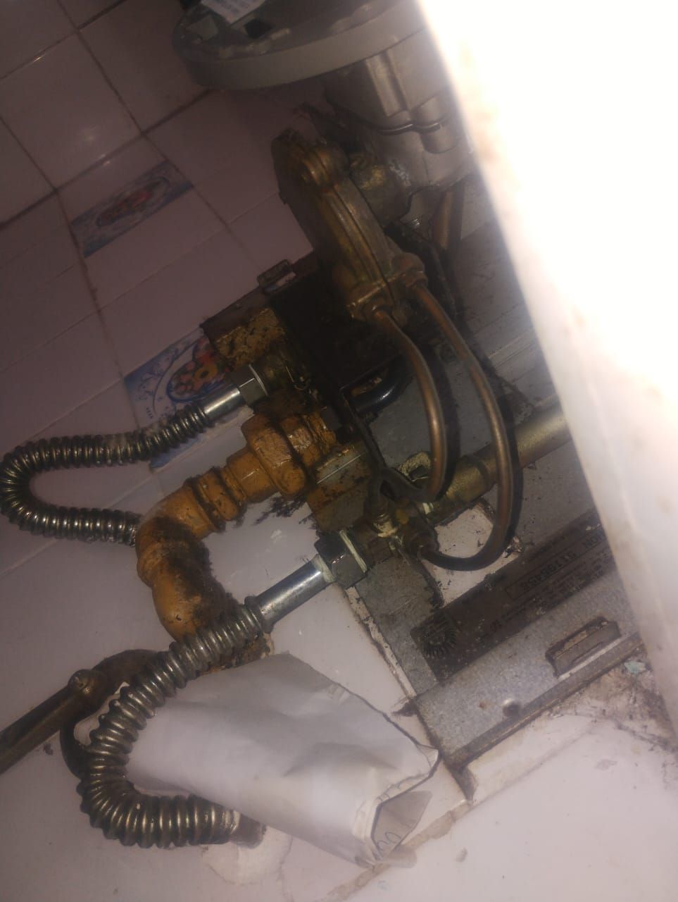 Primer plano del conjunto de válvulas de un calentador de agua a gas.