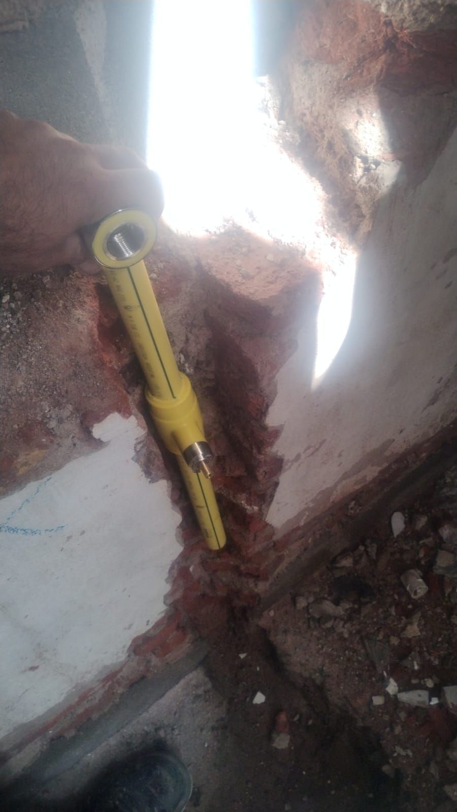 Conexión de tubería de gas amarilla en una zanja, posiblemente durante la instalación o reparación.