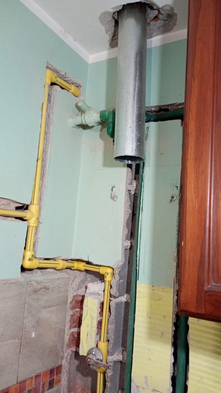 Cocina con tuberías de gas a la vista (amarillas) y conducto de ventilación.