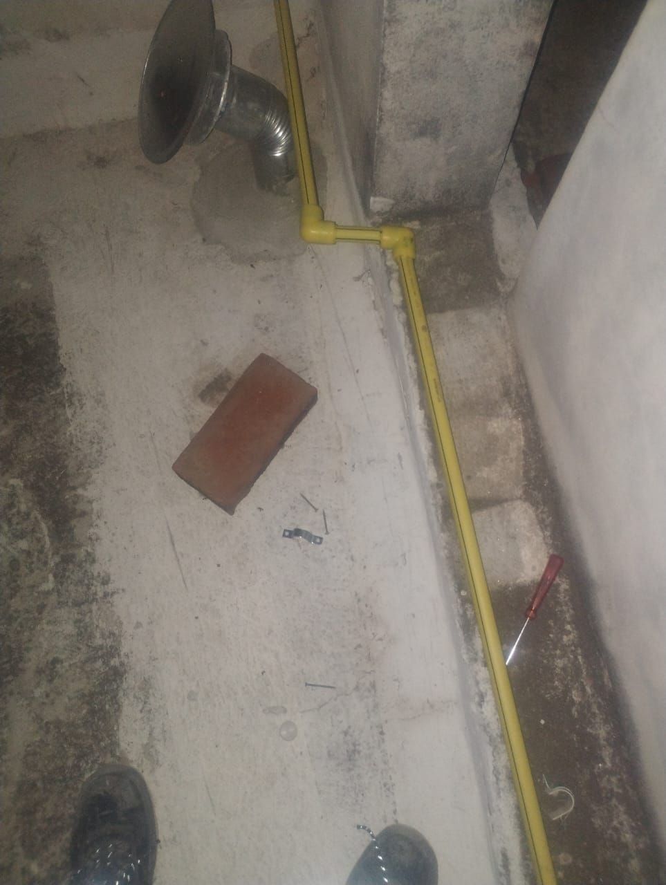 Tuberías de gas amarillas recorren una pared de hormigón, conectadas a una instalación metálica.