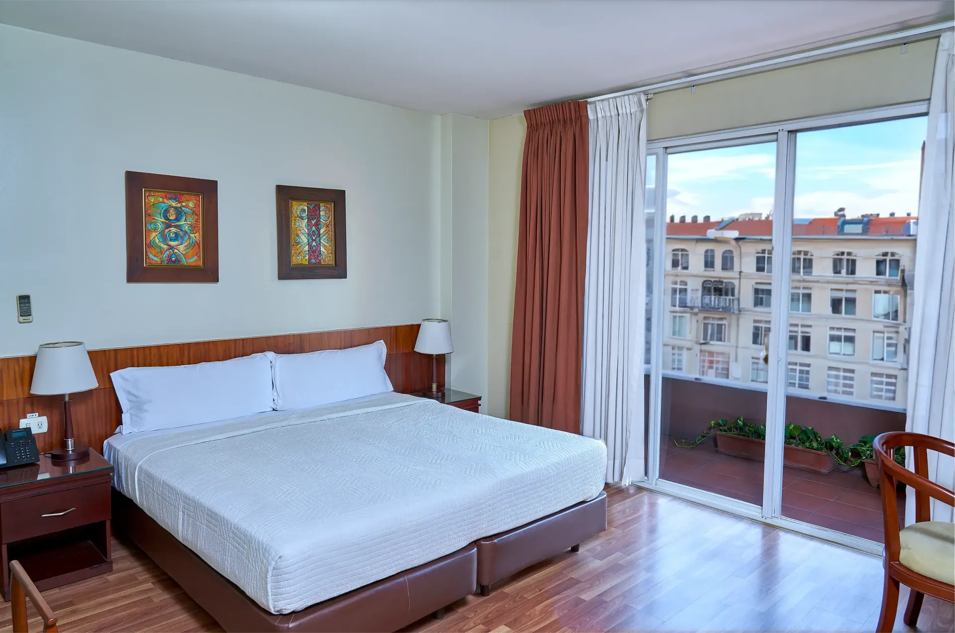 A hotel room with a large bed and sliding glass doors