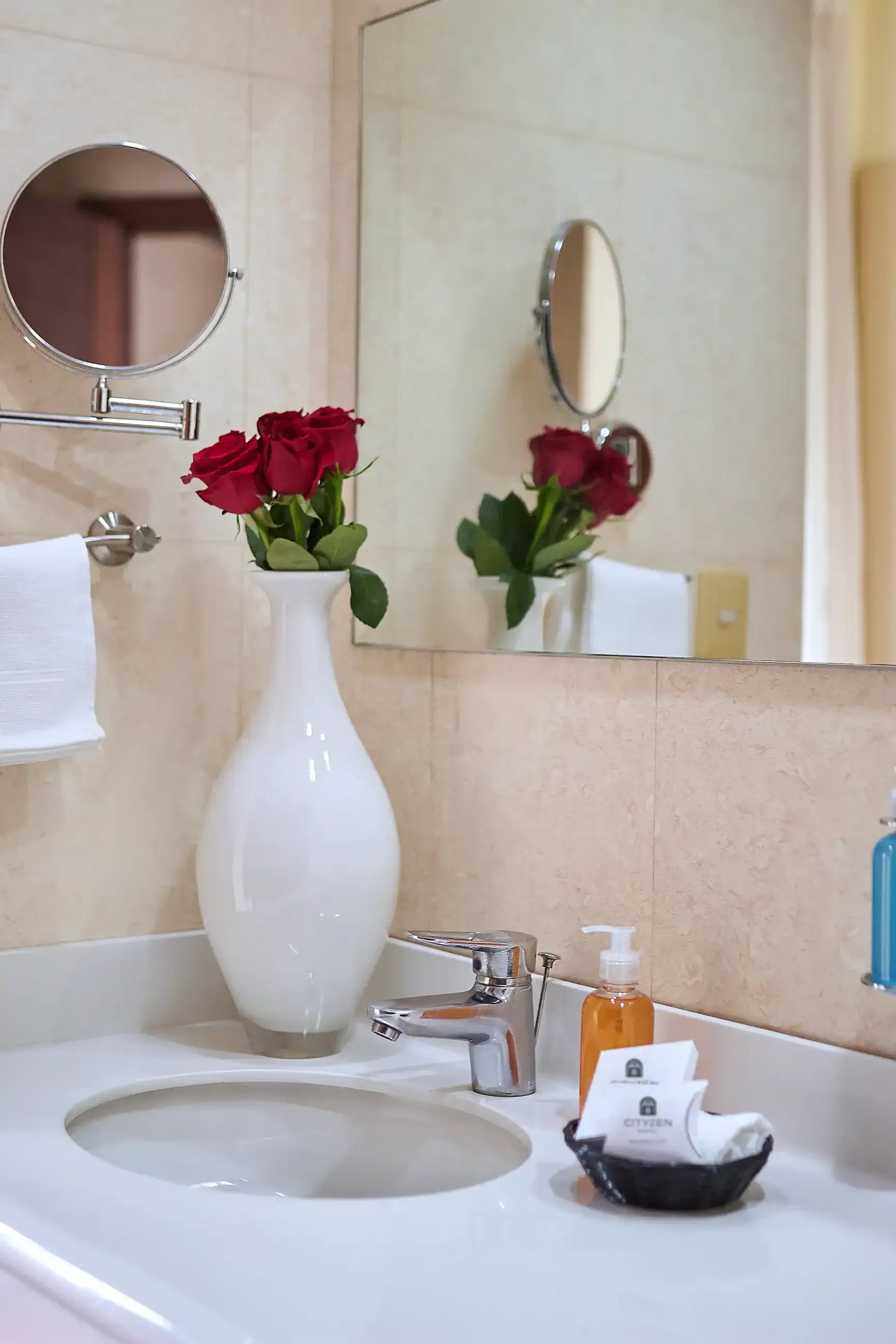 A bathroom sink with a vase of flowers on it