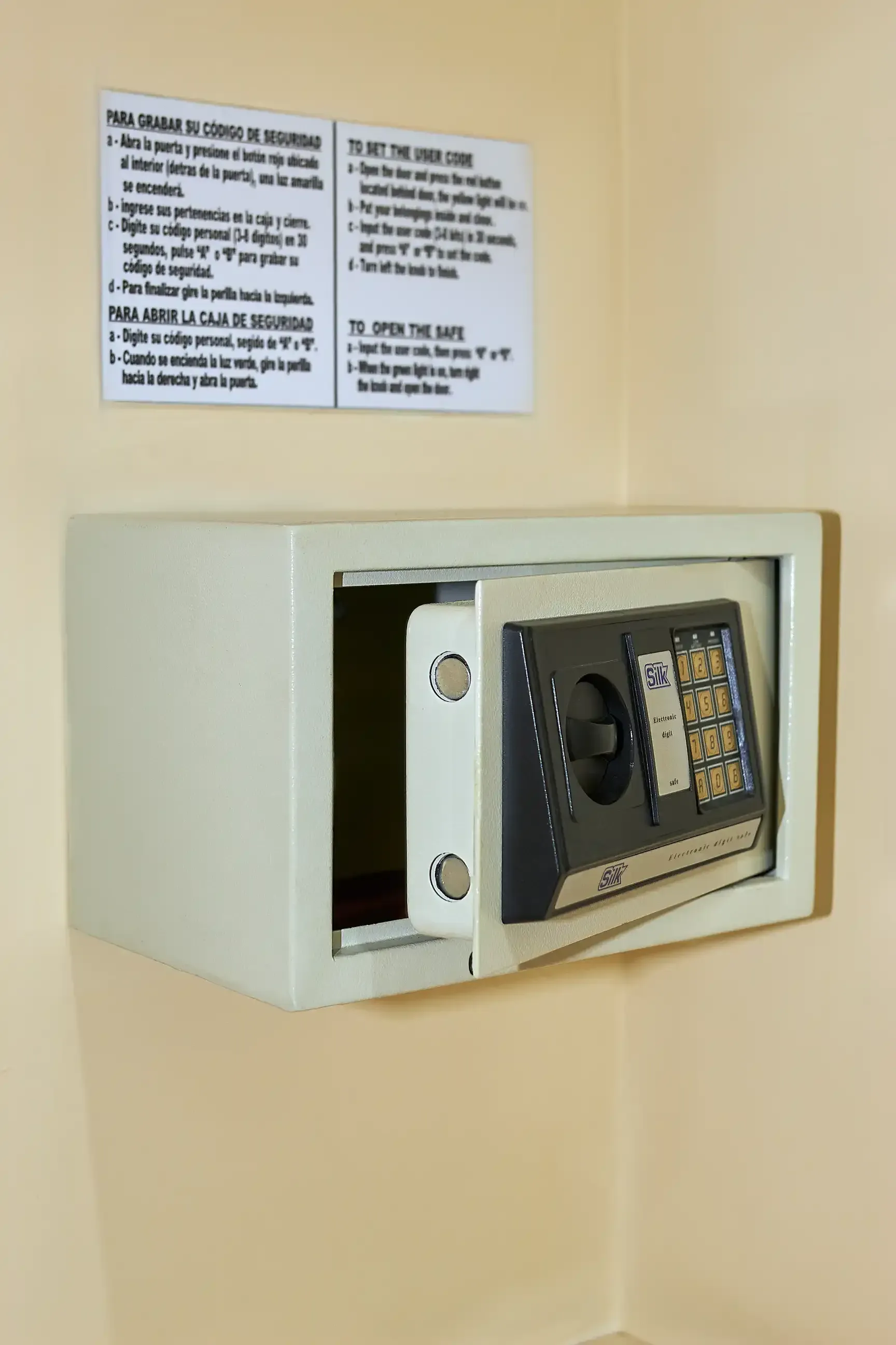 A safe is hanging on a wall with the door open.