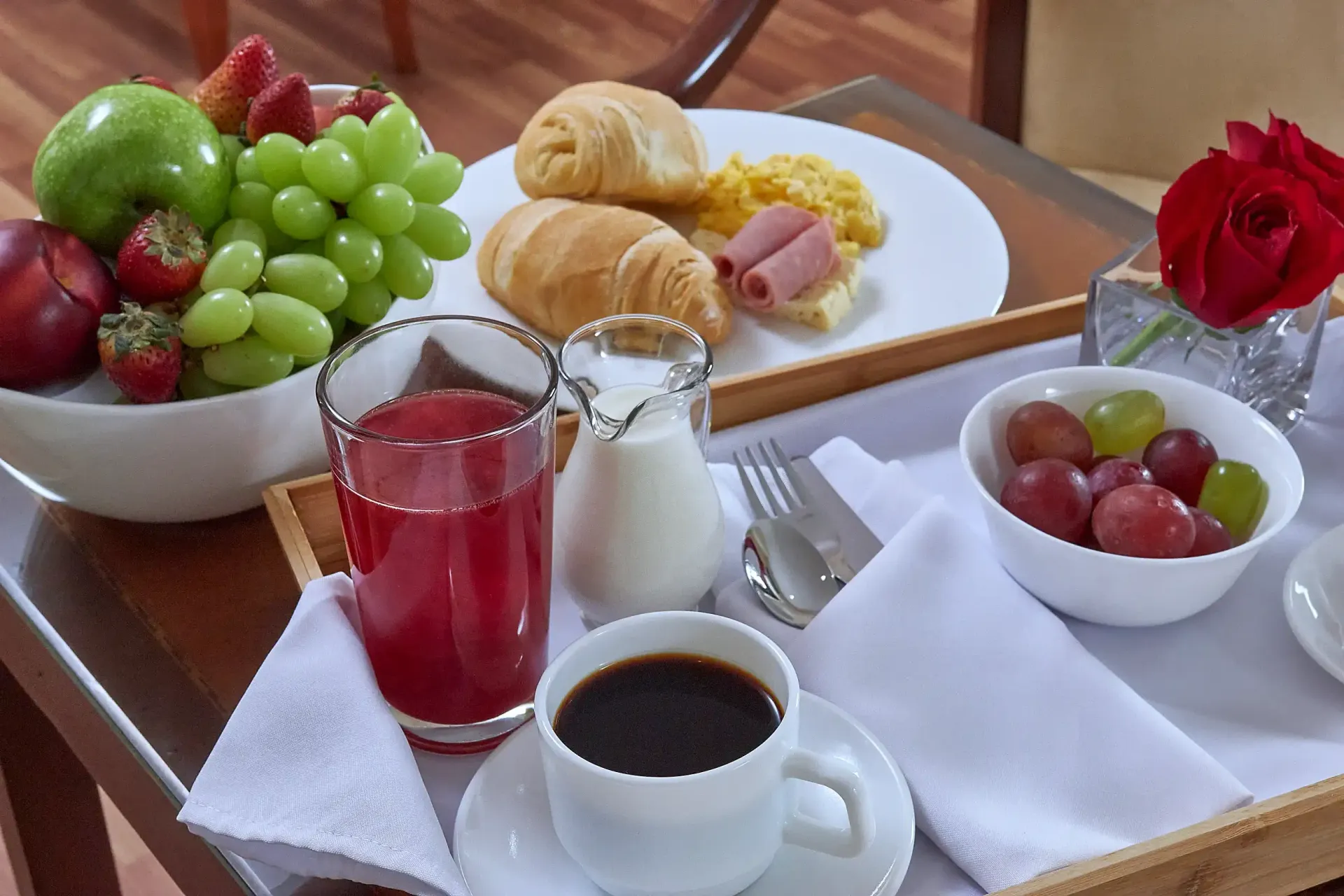 A tray with a cup of coffee and a bowl of fruit