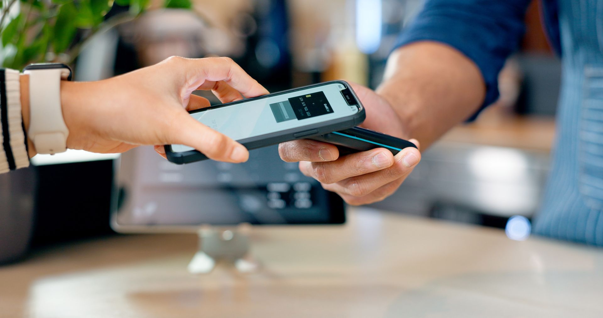 A person is paying with a smart phone in a store