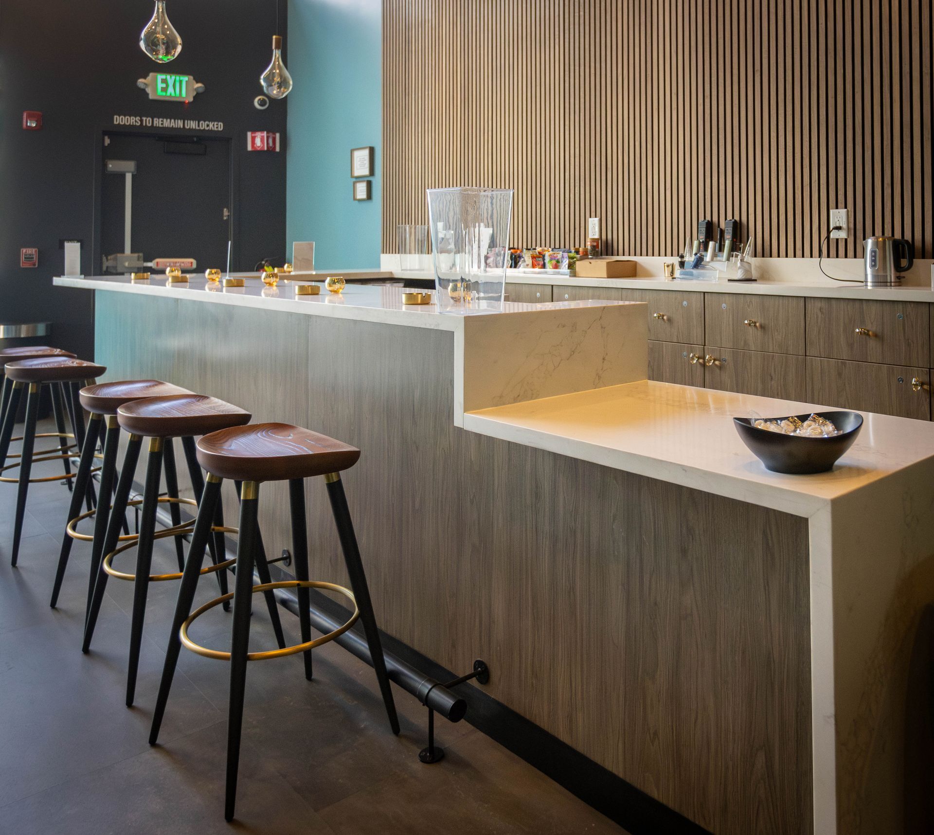 Bar with wooden stools, white countertop, and wooden paneling.