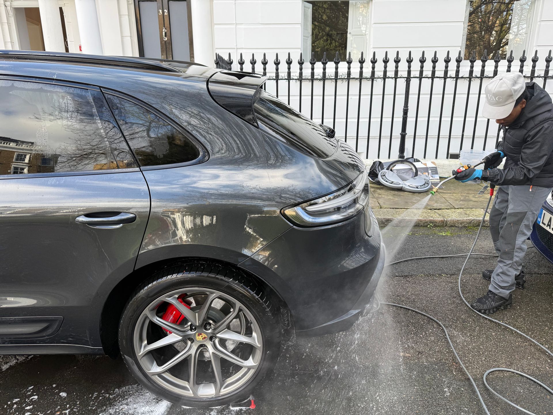 Black van with open doors parked on a street next to an Audi and a small white car.
