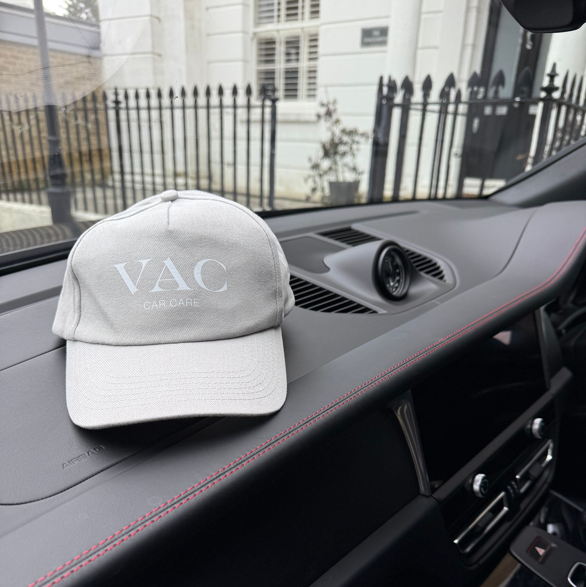 Blue McLaren sports car parked on cobblestone driveway.