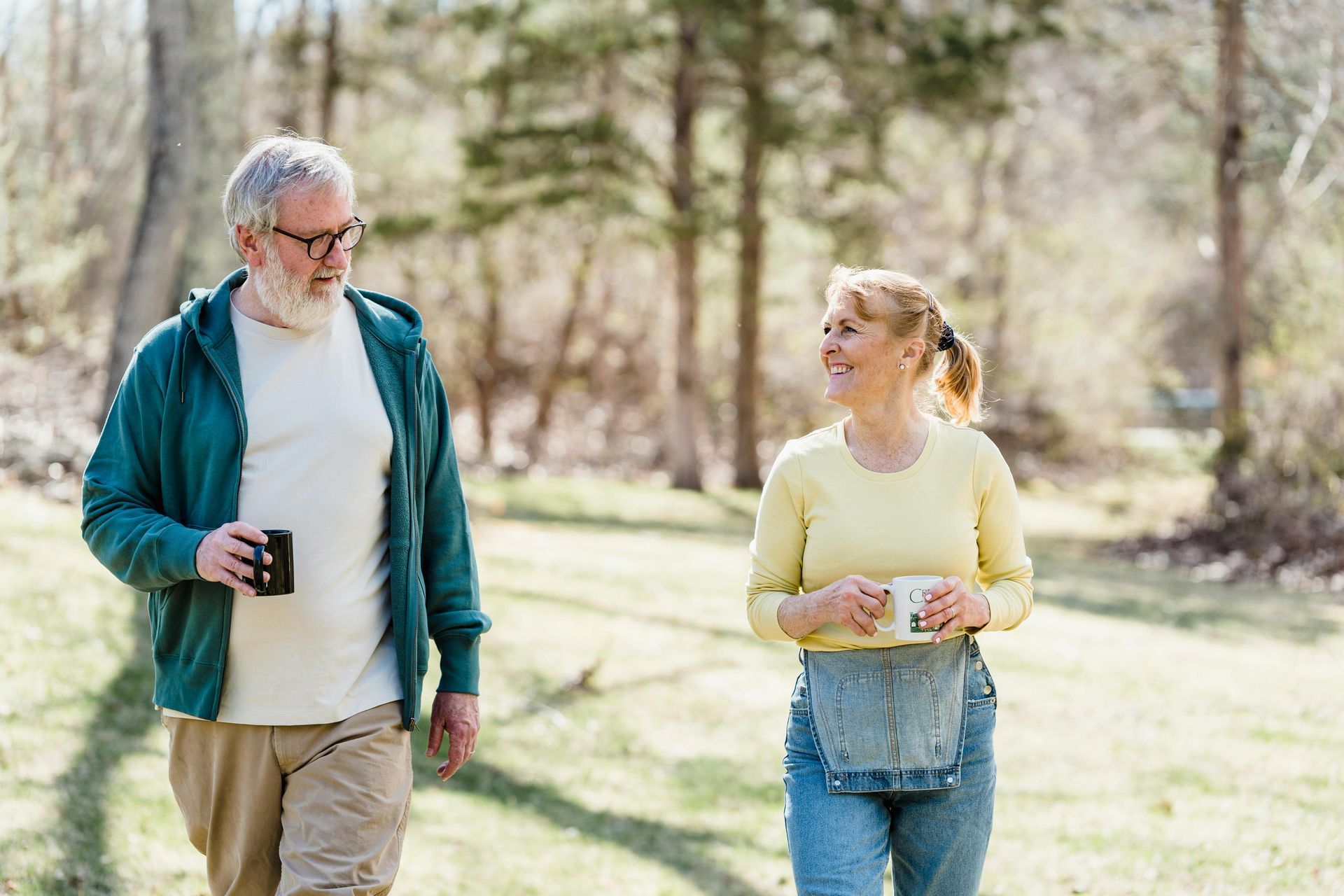 A man and a woman are walking in the woods.