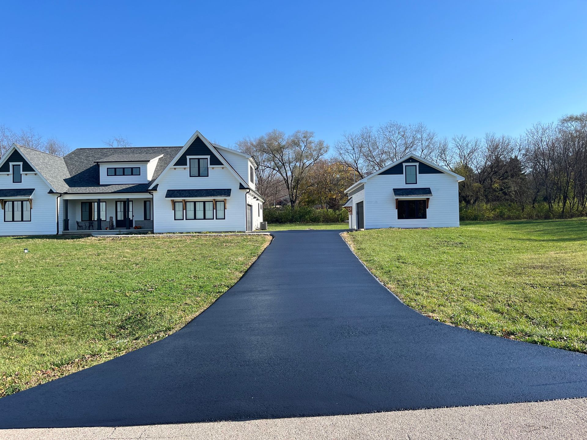 A Man Is Working On A Driveway With A Bulldozer - Capron, IL - Majestic Asphalt & Snow Services