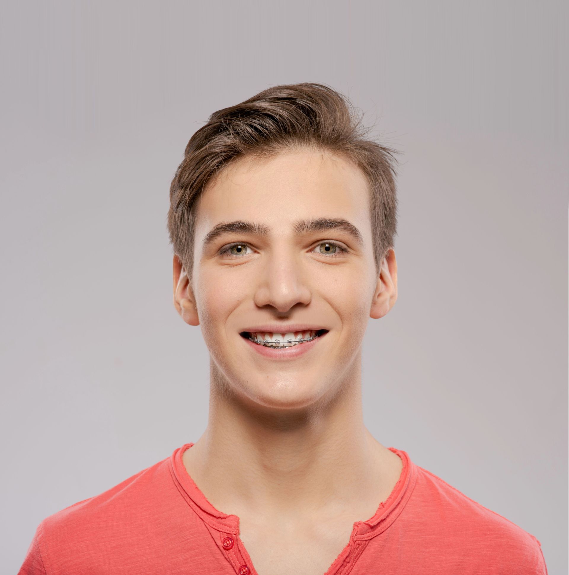 A young man wearing braces is smiling for the camera.