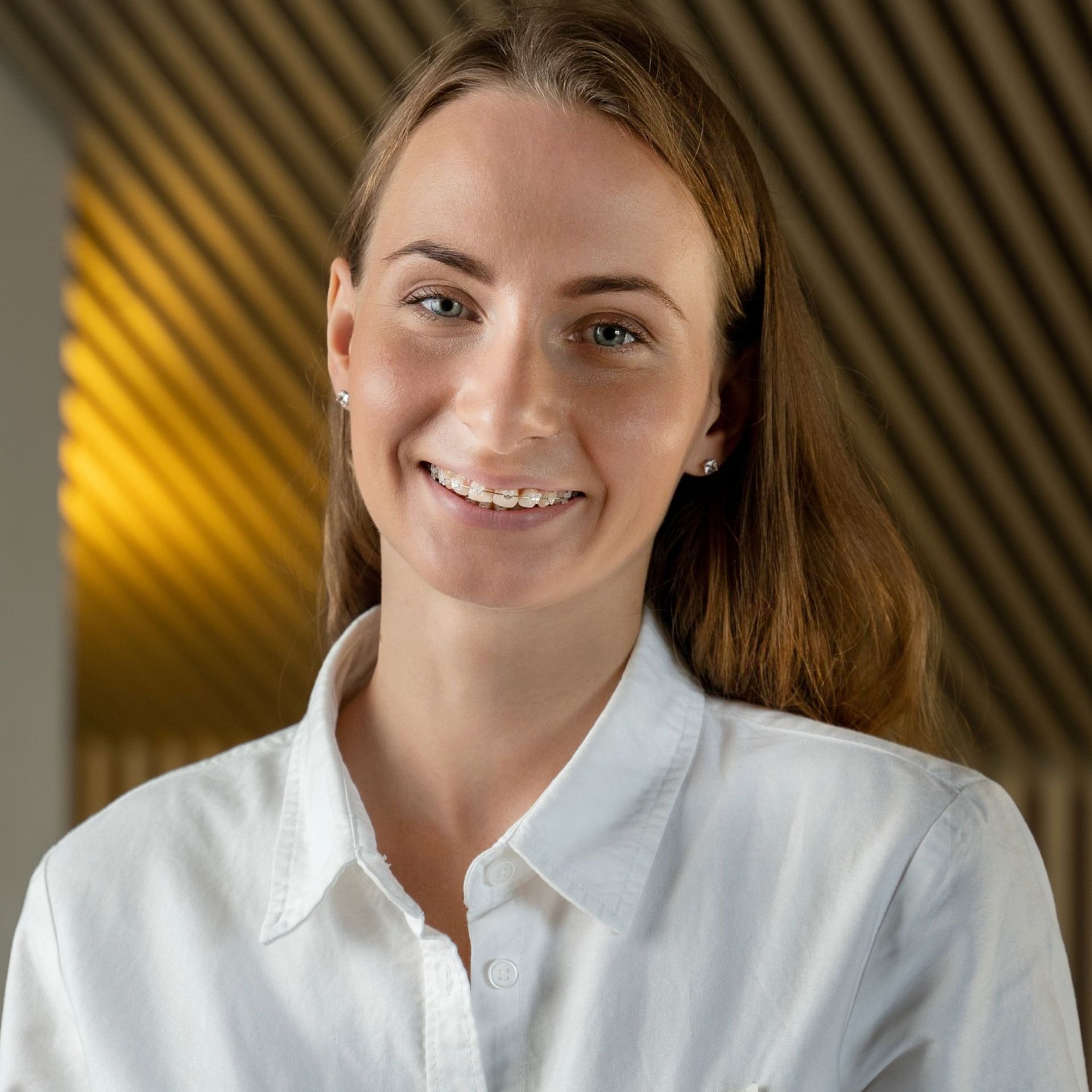 A woman in a white shirt is smiling for the camera