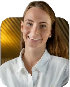 A woman in a white shirt is smiling for the camera