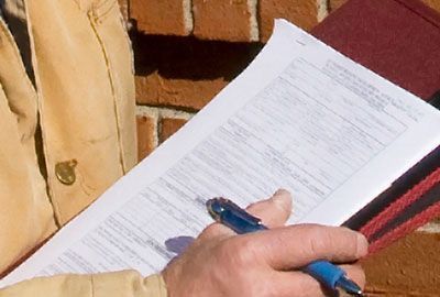 A Person is Writing on a Piece of Paper - Youngstown, OH - Radon Raiders