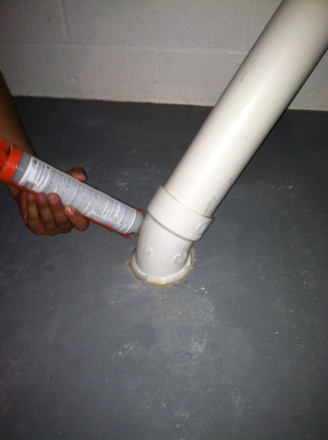 A Person is Applying Sealant to a White Pipe - Youngstown, OH - Radon Raiders