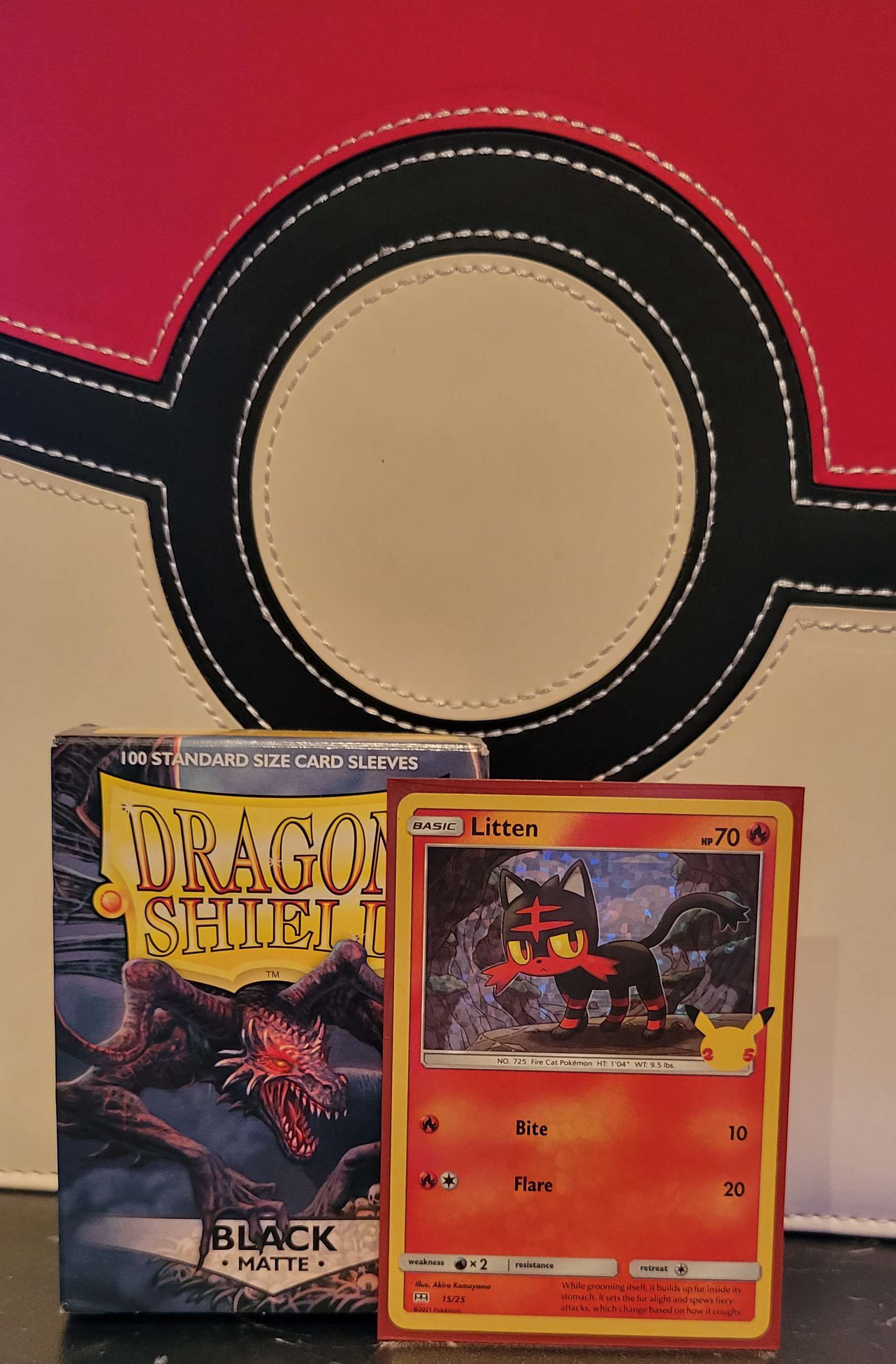 a pokemon card is sitting next to a box of dragon shield card sleeves