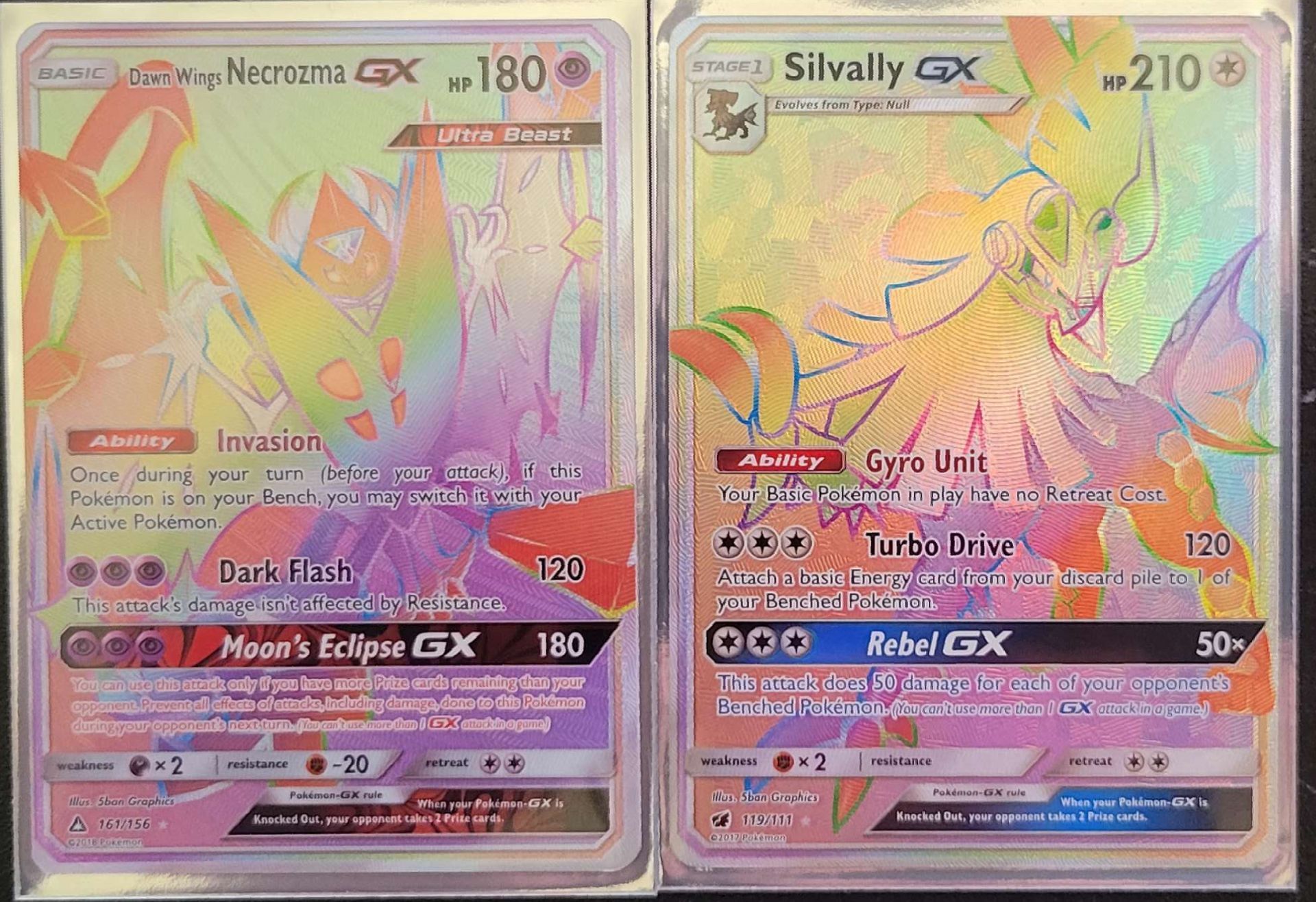 two rainbow Pokémon cards sitting next to each other