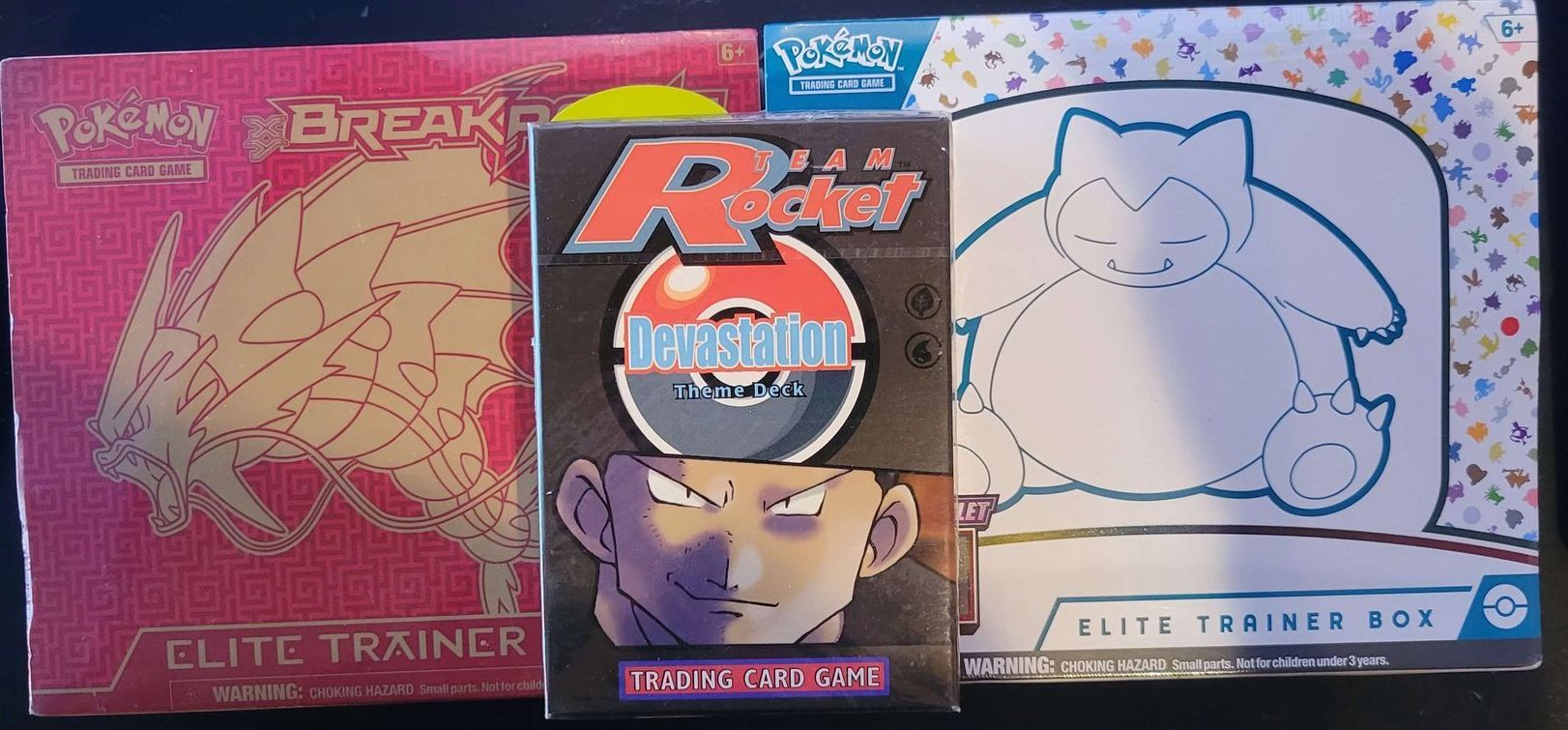 two pokemon elite trainer boxes sitting on a table with a theme deck sitting on top of them 
