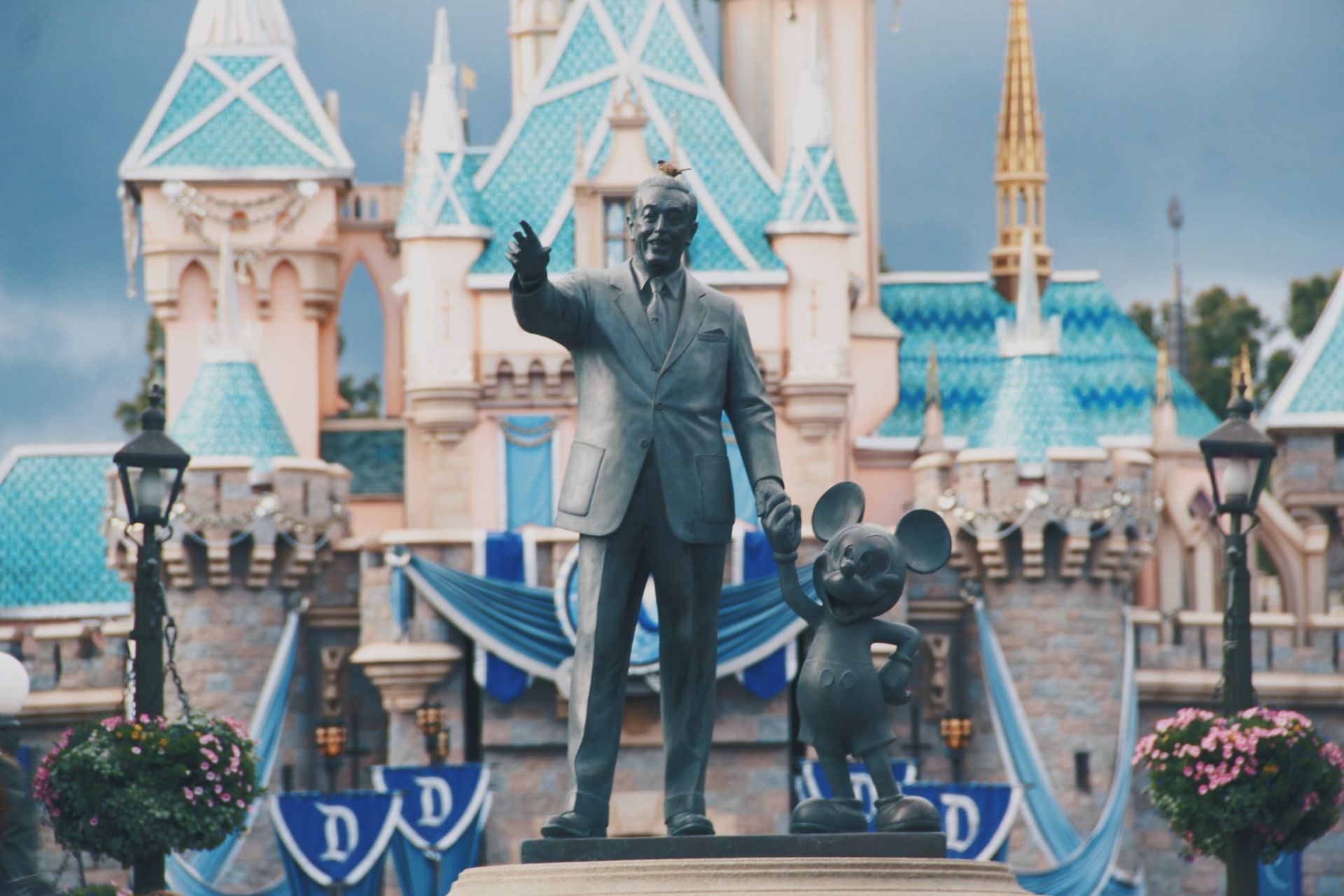 Walt Disney statue  in front of magic kingdom castle