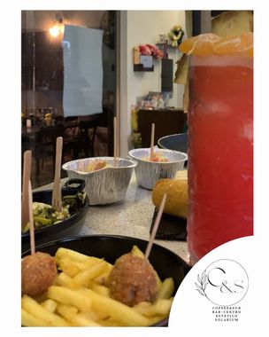Un tavolo apparecchiato con patatine fritte, polpette e una bevanda.