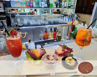 Un bar con una varietà di bevande e cibo sul bancone.